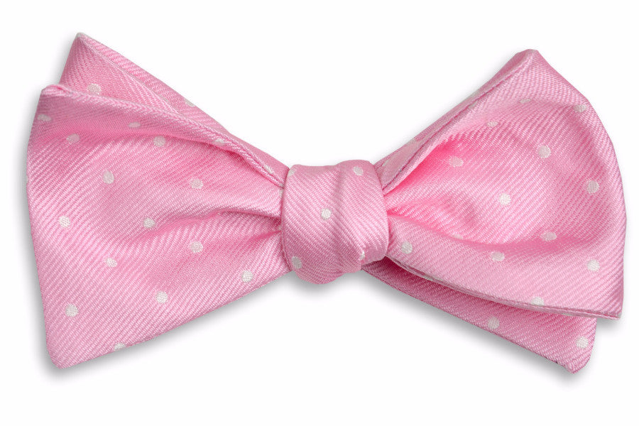 Men's pale pink bow tie. Made from 100% silk featuring white polka dots.