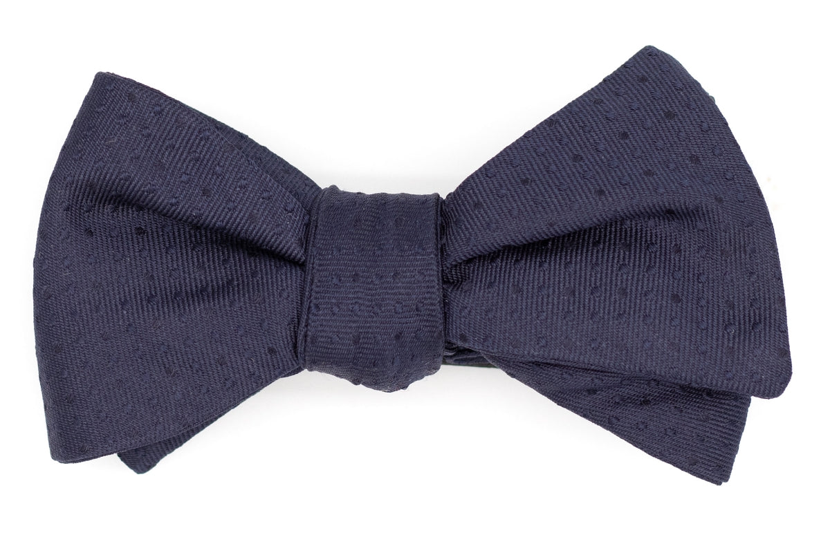  Italian silk mens bow tie. The dark navy color has a textured polka dot design.