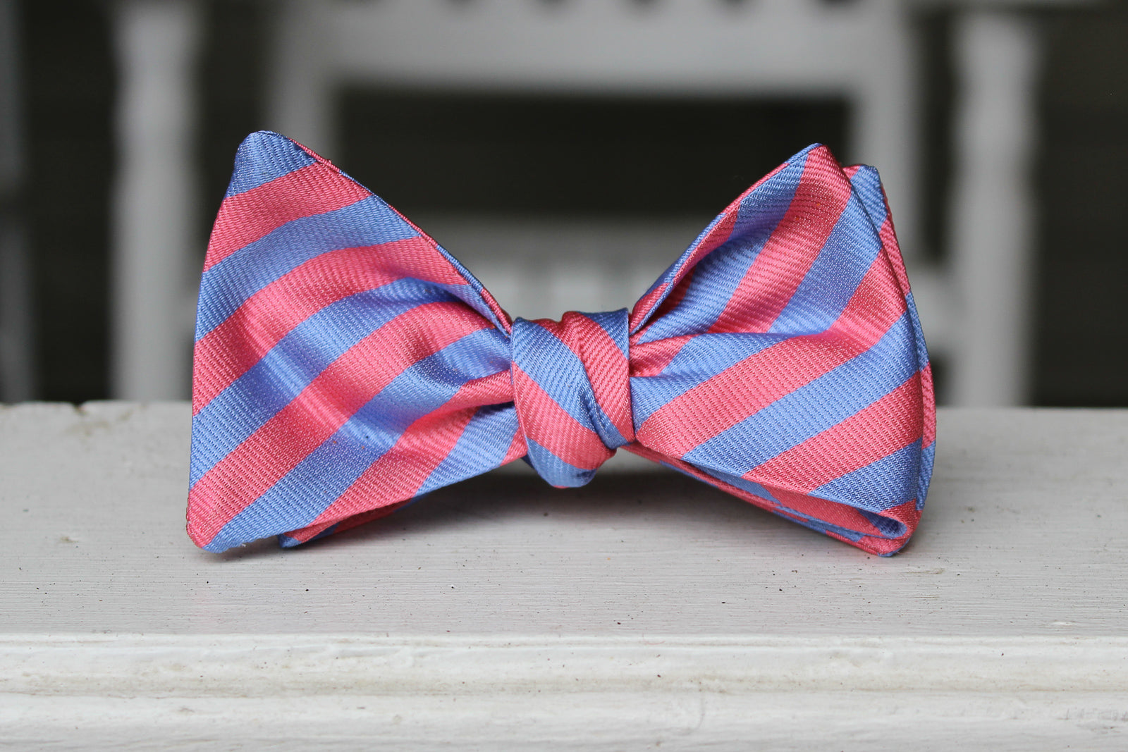 Pink and blue men's bow tie. Made from 100% silk with a striped pattern.