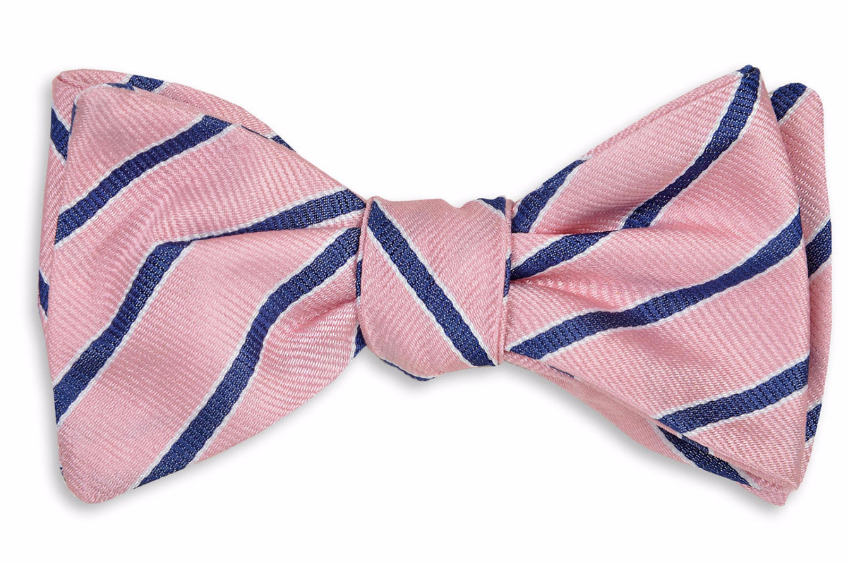 Pink men&#39;s bow tie. Made from 100% silk featuring blue stripes.